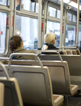 This shows a photo of two people riding a bus.