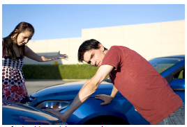 This shows a photo of two people assessing the damage to their cars after a collision.