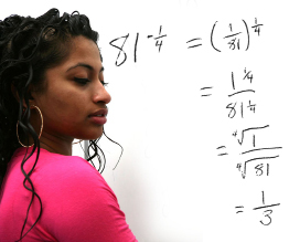 This shows a photo of a student writing the solution to a math problem on the whiteboard.