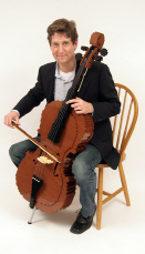 This shows a photo of Nathan Sawaya playing a life-size cello made out of Lego bricks.