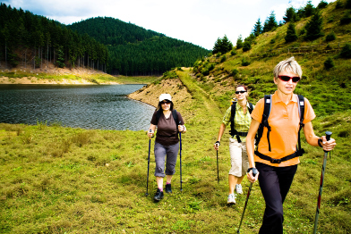 This is a photo of three women hiking along a stream in the wilderness.