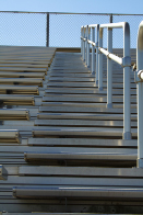 This shows a photo of the steps leading up some outdoor bleachers.