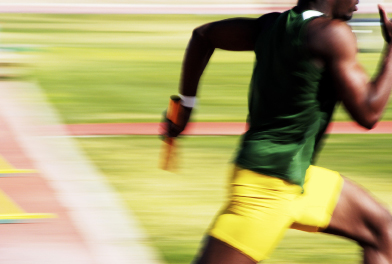 This shows a photo of an athlete sprinting on a track with a baton in his hand.