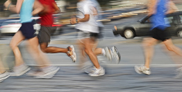 This photo shows a group of people jogging in a city.