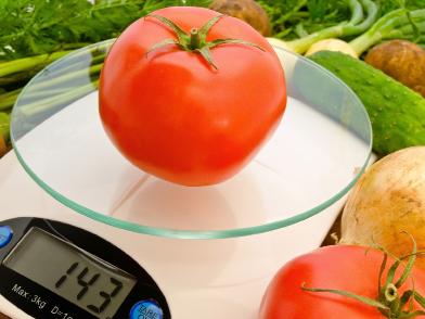 This photo shows a tomato being weighed on a weigh scale.