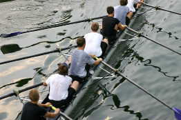 This shows a photo of seven rowers competing in a race.