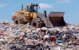 This shows a photo of a front-end loader shovelling garbage at a landfill.