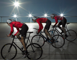 This shows a photo of three cyclists on a velodrome track.