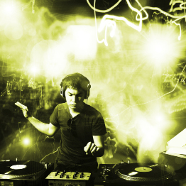 This shows a photo of a music deejay sitting in front of two record turntables as special effects take place behind him.