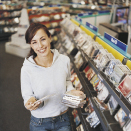 This shows a photo of a young woman in a music store with several CDs in her hand.