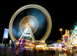 This shows a photo of the entrance to an amusement park at night.