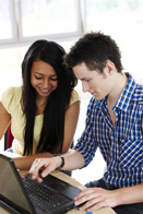 This is a photo of two students looking at a laptop computer.