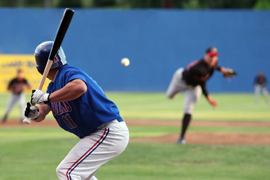 This photograph shows a baseball being pitched to a batter.