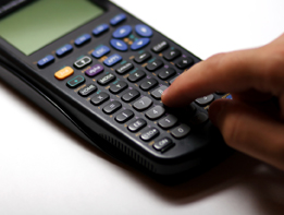 This shows a calculator and person’s finger pushing a button on the calculator.