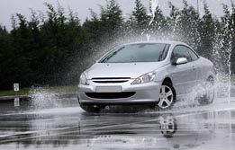 This is a photograph of a car skidding on a wet road.