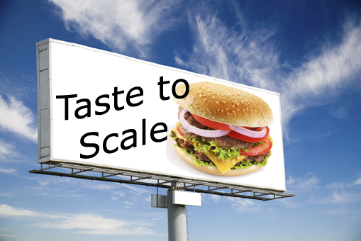 This is a photo of a billboard with the caption Taste to Scale beside a picture of a hamburger.