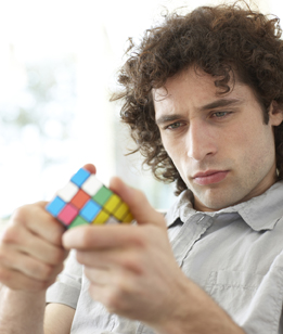 This is a photo of a man playing with a Rubik’s Cube.