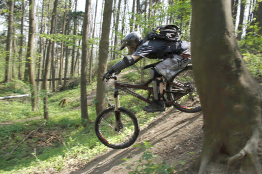 In this photo, a cyclist rides downhill on a mountain bike.