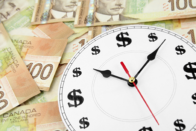 This shows a photo of a clock resting on top of a pile of $100 bills. The clock face has dollar signs in place of numbers.