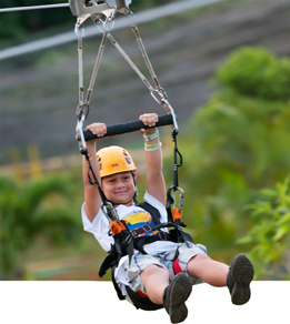 This is a photo showing a boy riding a zipline.