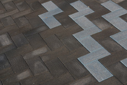 This shows a photo of the zigzag design of textured and non-textured bricks in a plaza.