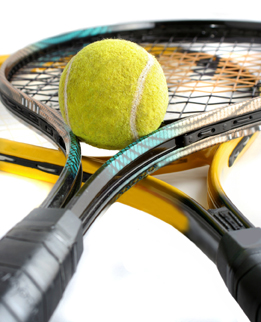 This shows a photo of a tennis ball on top of two tennis racquets.