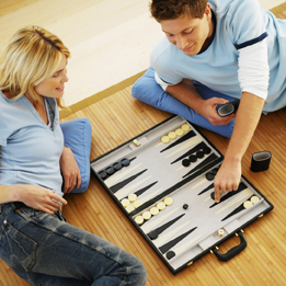 This is a photo of a young man and woman playing backgammon.