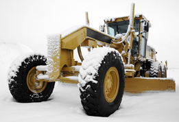 This is a photo of a grader covered with snow.