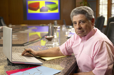 In this photo, a man with a laptop is preparing a pie chart.