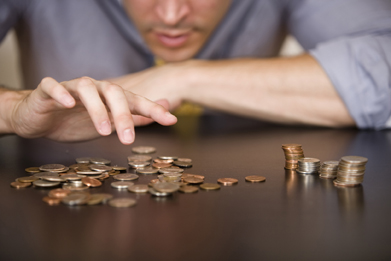 In this photo a man is counting his coins.