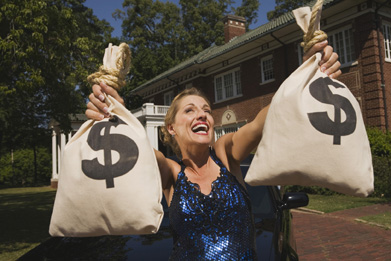 In this photo a woman is holding two bags of money.