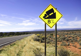 This is a photo of a road sign with slope information for truckers.