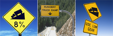 These three photos are of road grade signs. One sign notes eight percent, one indicates truckers should use low gear, and another sign notes a runaway ramp.