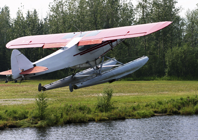 This is a photo of a Noorduyn Norseman plane lifting off of a lake. 