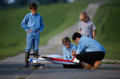 This is a photo of people preparing to fly a model airplane. 