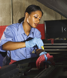 This is a photo of a female mechanic working on a vehicle.