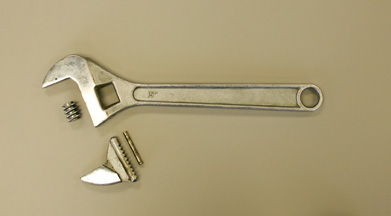This is a photo of a 10-inch adjustable wrench (spanner) taken apart.