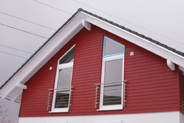 In this photo, a house has a gable end with windows.