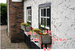 This is a photo of a window box with flowers planted in it. The trapezoidal end of the box is 14.9 inches tall, 8 inches wide at the bottom, and 12 inches wide at the top. The rectangular front of the box is 15 inches tall and 30 inches wide.