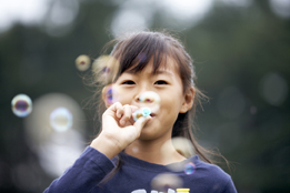 This is a photo of a young girl blowing bubbles.