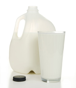 This photo shows an open jug of milk and a glass filled with milk.