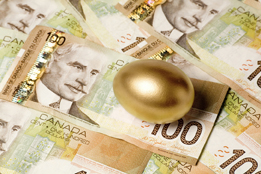 This is a photo of Canadian one hundred dollar bills and a golden egg.