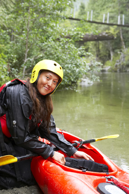 This is a picture of woman next to a kayak.