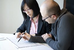 This is a photo of two people looking at papers.