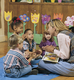 This image shows a teacher with a small group of kindergarten students.