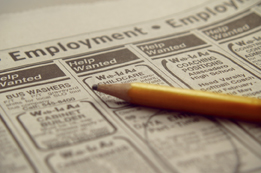 This is a photograph of the wanted ads of a newspaper with a yellow pencil on the paper.