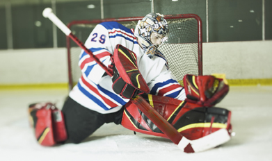 This is a photograph of an ice hockey goalie attempting to make a save.