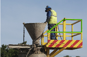 This photograph shows a worker on a cement-pouring stand with a quadrilateral outlined in green.