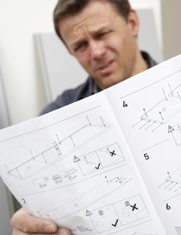 This is a photograph of a person looking at a furniture parts list.