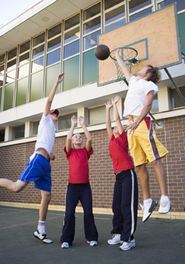 This is a photo of some teenagers playing basketball outside.